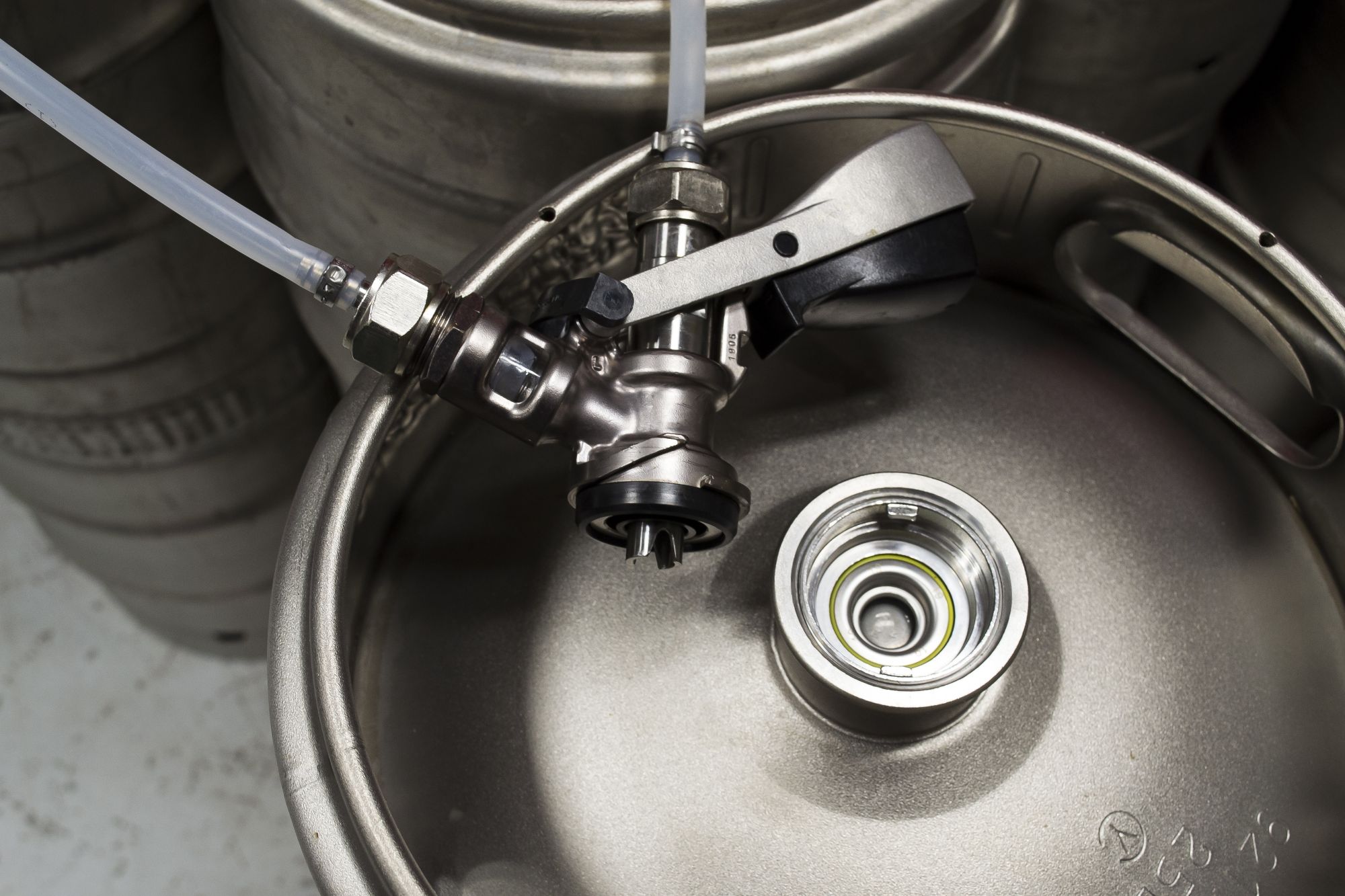 Close-up of a stainless steel beer keg with a securely attached tap system.