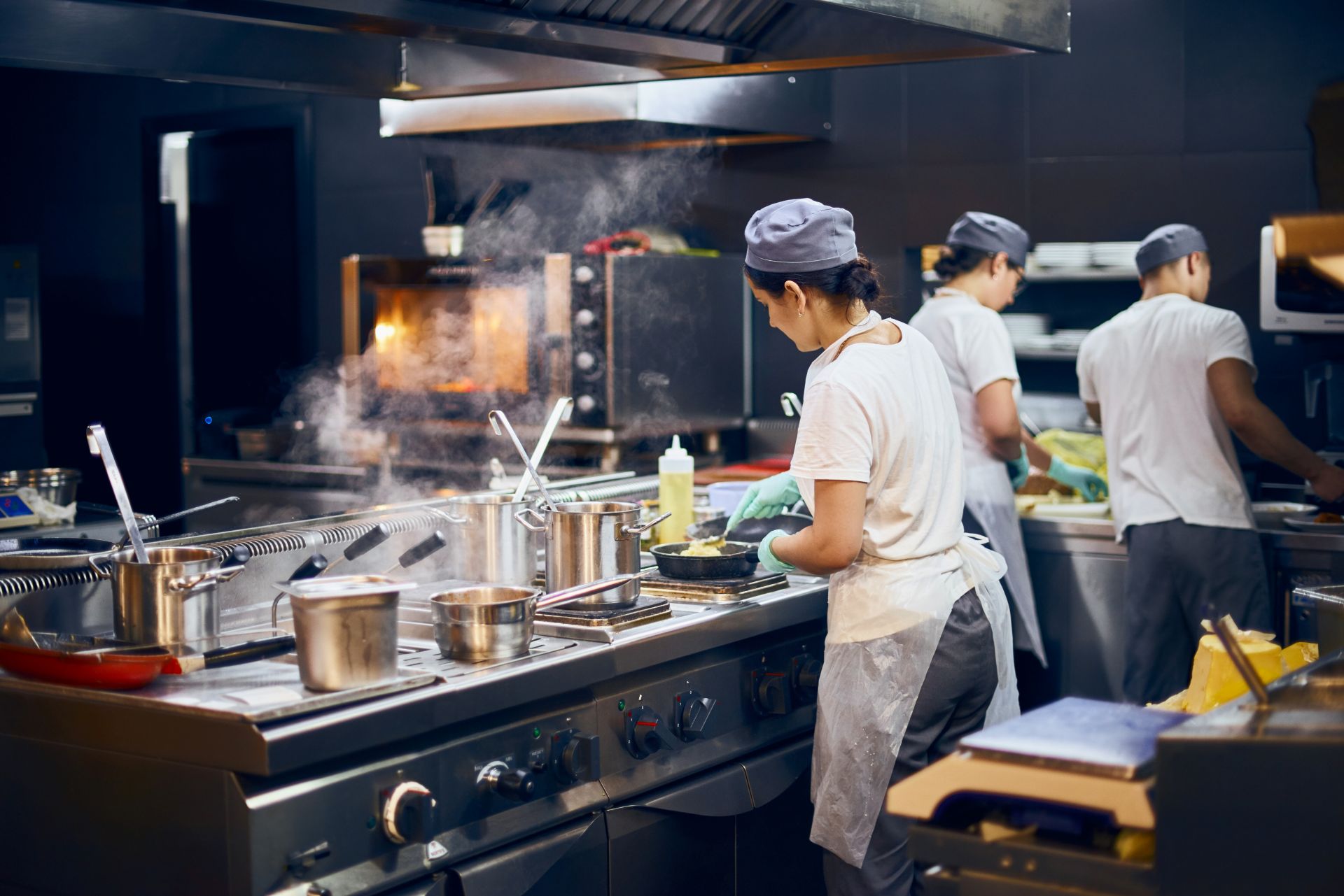 the team of cooks backs in the work in the modern kitchen, the workflow of the restaurant in the kitchen